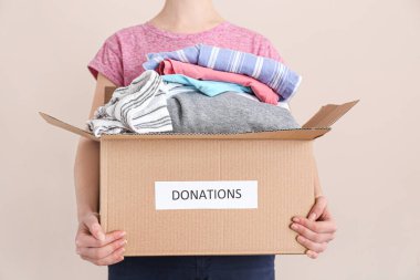 Renkli arka planda bağışları olan kutucuğu tutan kadın