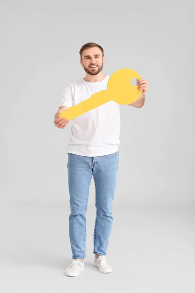 Joven Feliz Con Gran Llave Papel Sobre Fondo Gris —  Fotos de Stock