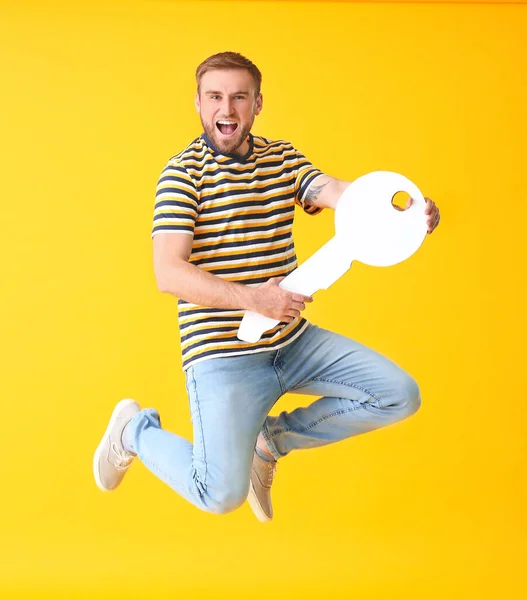 Jumping Young Man Big Paper Key Color Background — Stock Photo, Image