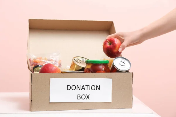 Mujer Poniendo Productos Caja Donación Mesa — Foto de Stock