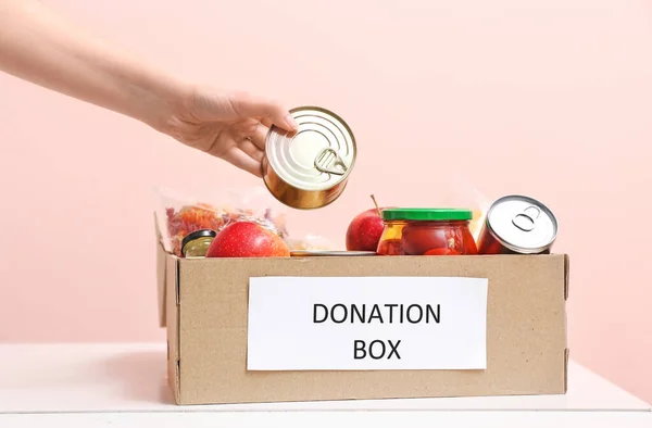 Mujer Poniendo Productos Caja Donación Mesa — Foto de Stock