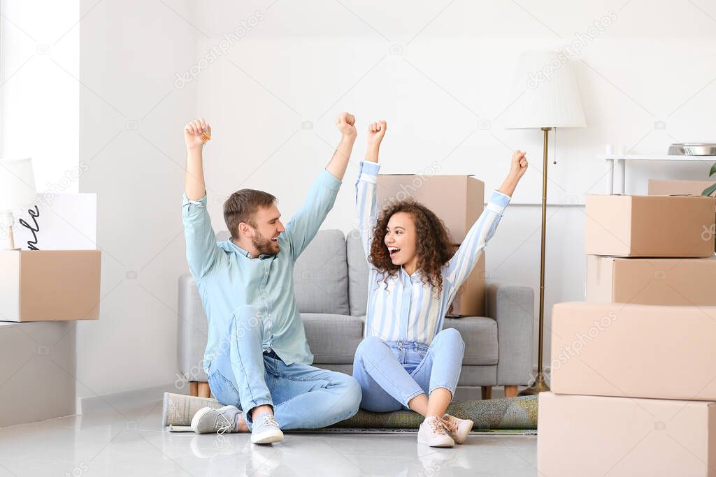Happy young couple in their new flat on moving day