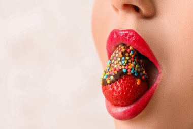 Hafif arka planda çilekli seksi genç kadın, yakın plan.