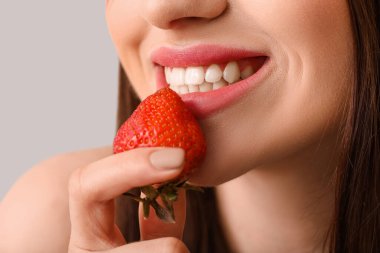 Açık arkaplanda çilekli seksi genç kadın, yakın plan.