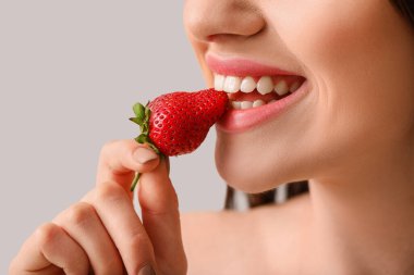 Açık arkaplanda çilekli seksi genç kadın, yakın plan.
