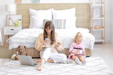 Küçük kızıyla evde çalışan bir anne.