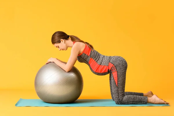 Mujer Embarazada Joven Entrenando Contra Fondo Color —  Fotos de Stock