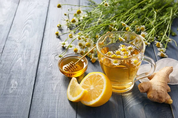 Chamomile tea with honey, lemon and ginger on table