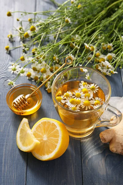 Chamomile tea with honey, lemon and ginger on table