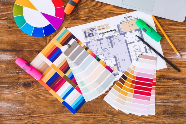 Color palettes with building plan on wooden background