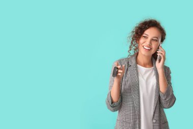 Anahtarı olan mutlu genç bir kadın telefonla konuşuyor.