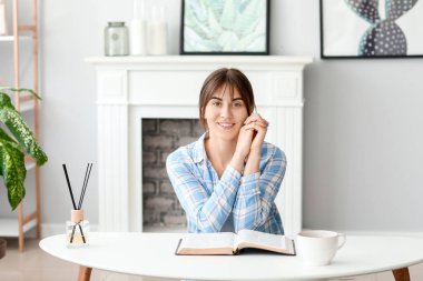 Evde İncil 'i olan genç bir kadın.