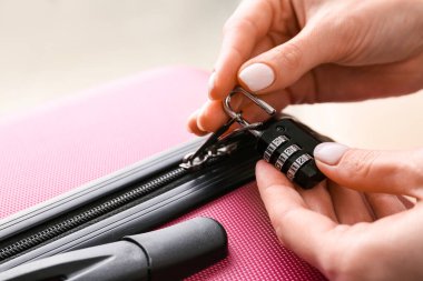 Kadın valizin kilidini açıyor, yakın plan.