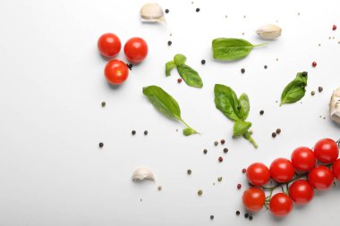 Beyaz arka planda fesleğen, domates ve baharatlı kompozisyon