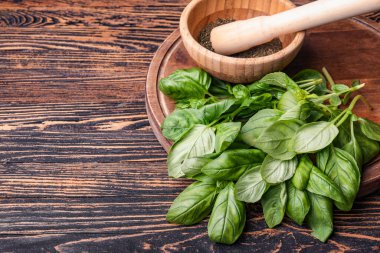 Taze yeşil fesleğen, harç ve ahşap zemin üzerinde tokmak.