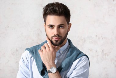 Açık arkaplanda şık saç stili olan yakışıklı adam.