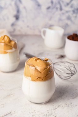 Beyaz arka planda bir bardak lezzetli dalgona kahvesi.