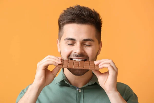 Joven Guapo Con Sabroso Chocolate Sobre Fondo Color — Foto de Stock