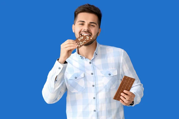 Joven Guapo Con Sabroso Chocolate Sobre Fondo Color — Foto de Stock