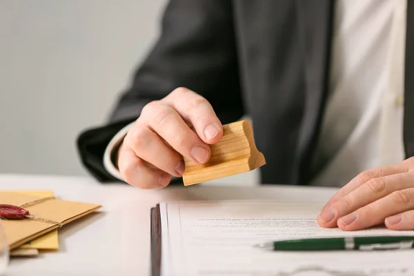 Notary public with stamp working in office, closeup