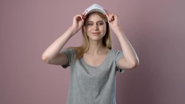 Mujer Joven Tratando Elegante Gorra Contra Fondo Color — Vídeos de Stock