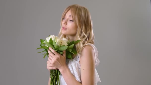 白玫瑰花束灰色背景的年轻漂亮女子 — 图库视频影像