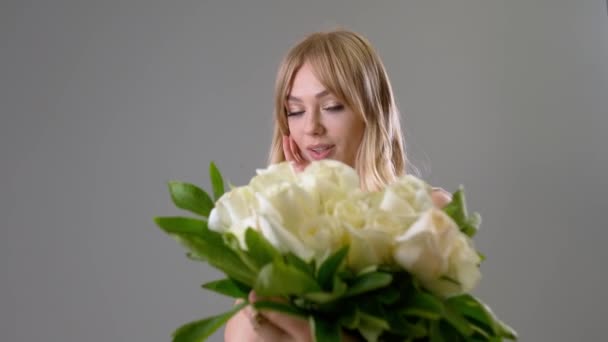 Hermosa Joven Recibiendo Ramo Rosas Blancas Sobre Fondo Gris — Vídeo de stock