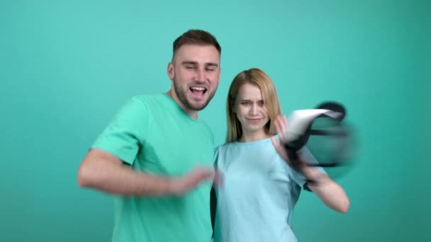 Lanzamiento Las Gorras Estilo Pareja Joven Sobre Fondo Color — Vídeo de stock