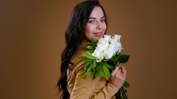Güzel Genç Bir Kadın Izleyiciyi Bir Buket Beyaz Gülle Selamlıyor — Stok video