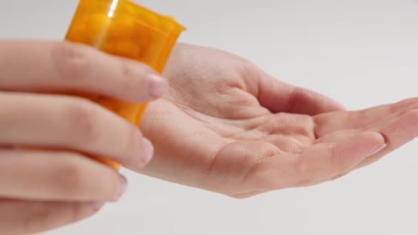 Donna Versando Pillole Bottiglia Palmo Sfondo Bianco Primo Piano — Video Stock