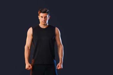 Sportif genç adam koyu arka plan üzerinde