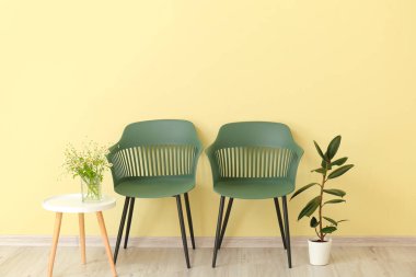 Sandalyeleri ve masası olan modern oturma odasının içinde.