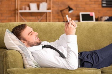 Uzun bir çalışma gününden sonra genç işadamı evinde dinleniyor.