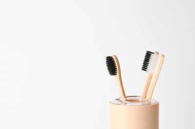 Açık arkaplanda diş fırçası olan tutucu