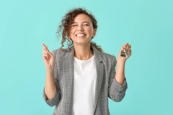 Happy Young Woman Key Crossed Fingers Color Background — Stock Photo, Image