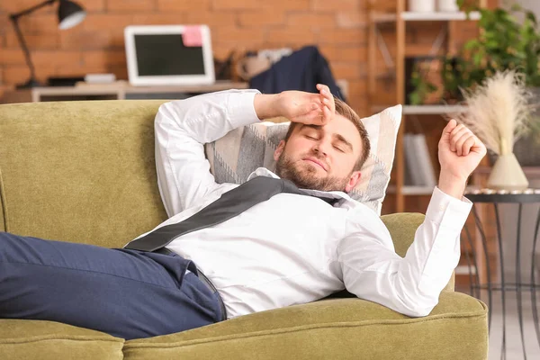 Young businessman resting at home after long working day