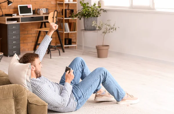 Lazy man with mobile phone spending day off at home