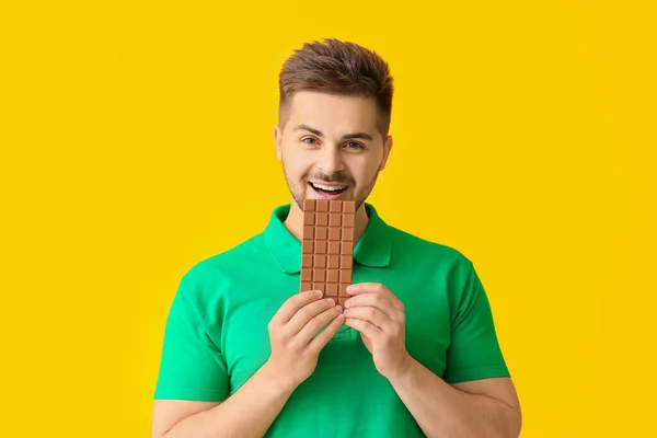 Joven Guapo Con Sabroso Chocolate Sobre Fondo Color — Foto de Stock