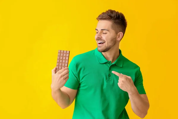 Joven Guapo Con Sabroso Chocolate Sobre Fondo Color — Foto de Stock