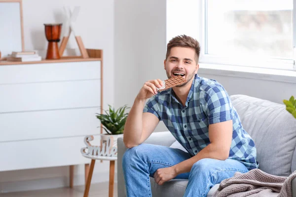 Evde lezzetli çikolataları olan yakışıklı bir genç.