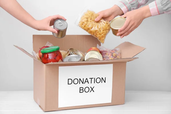 Voluntarios Poniendo Productos Caja Donaciones Mesa — Foto de Stock