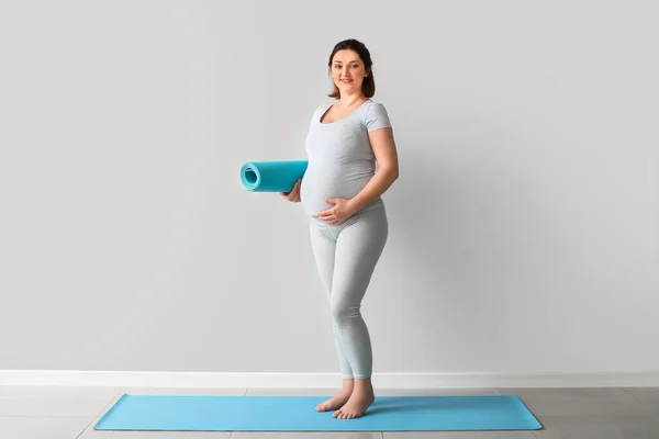 Jonge Zwangere Vrouw Met Yoga Mat Buurt Van Lichte Muur — Stockfoto