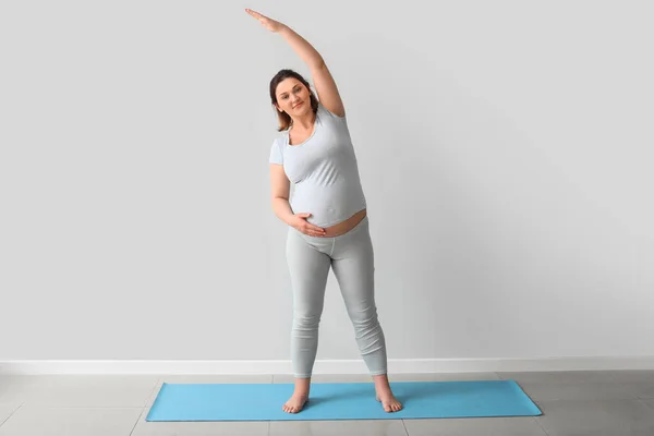 Jong Zwanger Vrouw Oefenen Yoga Buurt Van Licht Muur — Stockfoto