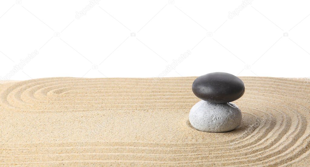 Stones on sand with lines against white background. Zen concept