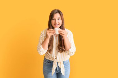 Arka planda sıcak kahve içen genç bir kadın.