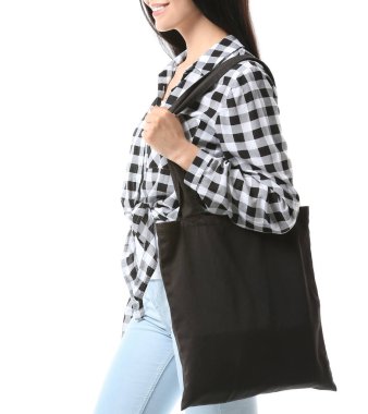 Beyaz arka planda çevre çantalı genç bir kadın.