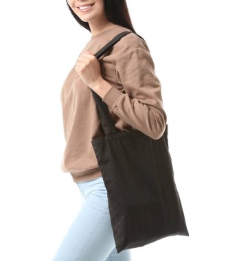 Beyaz arka planda çevre çantalı genç bir kadın.