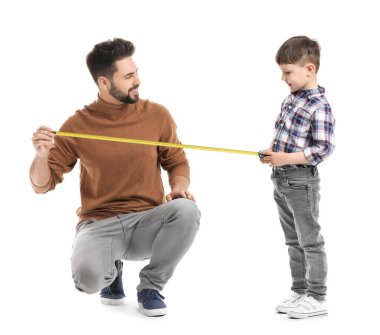 Beyaz arka planda mezurası olan baba ve oğul.