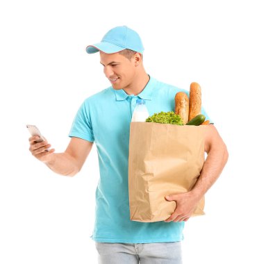 Paketinde yiyecek ve beyaz arka planda cep telefonu olan teslimatçı.