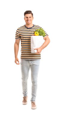 Beyaz arka planda yiyecek dolu çanta taşıyan genç bir adam.